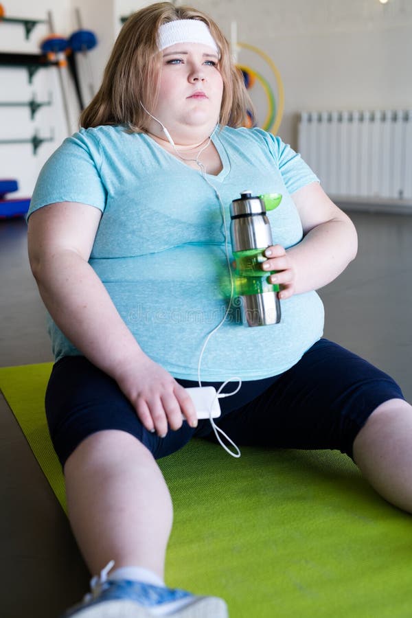 Donna obesa stanca che si siede sulla stuoia fotografie stock libere da diritti Donna obesa stanca che si siede sulla stuoia fotografie stock libere da diritti