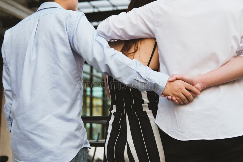 Donna omosessuale dell'abbraccio dell'uomo mentre tenendosi per mano con l'amante segreto immagine stock libera da diritti