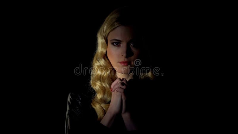 Donna peccatrice che prega in una stanza buia, alla ricerca del perdono, della fede e del credo