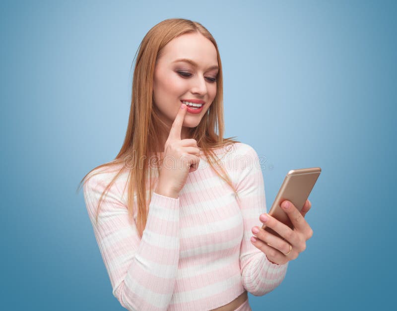 Donna pensierosa graziosa che per mezzo di nuovo telefono immagini stock libere da diritti Donna pensierosa graziosa che per mezzo di nuovo telefono immagini stock libere da diritti