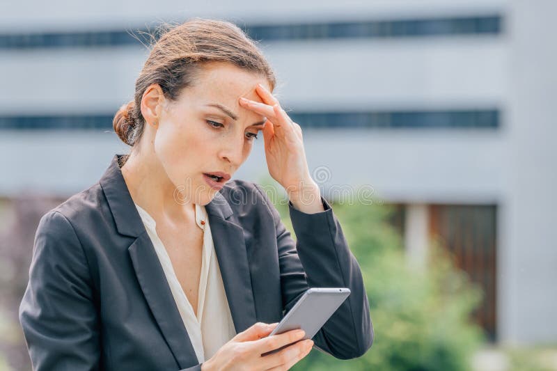 Donna per strada preoccupata di guardare il cellulare immagine stock libera da diritti