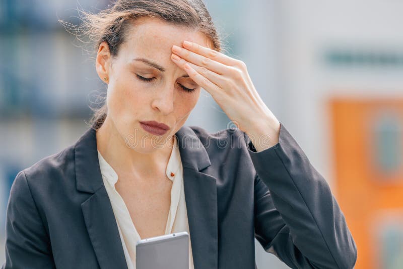 Donna per strada preoccupata di guardare il cellulare fotografie stock