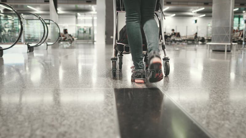 Donna portatrice di bagaglio a piedi al terminal dell'aeroporto