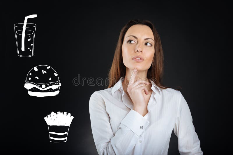 Donna premurosa che tocca il suo mento mentre scegliendo alimento in un caffè immagini stock Donna premurosa che tocca il suo mento mentre scegliendo alimento in un caffè immagini stock
