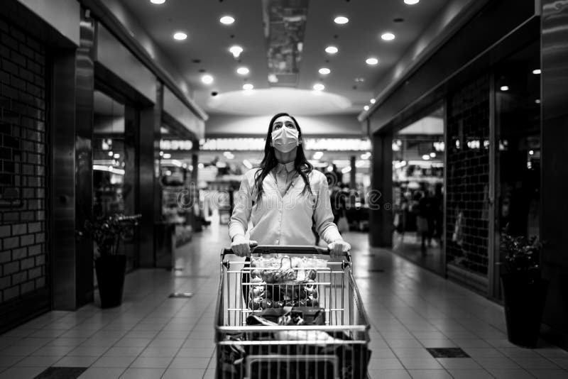 Worried woman with mask groceries shopping in supermarket,pushing trolley.Food panic buying and hoarding.Covid-19 quarantine shopper.Financial problems anxiety.Unemployed person in money crisis. Worried woman with mask groceries shopping in supermarket,pushing trolley.Food panic buying and hoarding.Covid-19 quarantine shopper.Financial problems anxiety.Unemployed person in money crisis