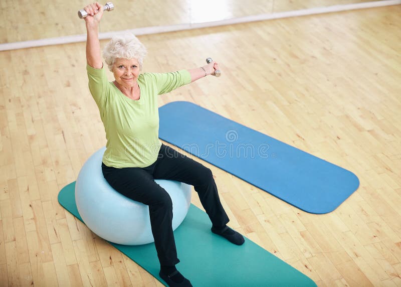 Donna senior attiva alla palestra che si esercita con i pesi