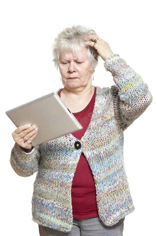 Donna senior che per mezzo del computer della compressa che sembra sconcertante immagine stock libera da diritti Donna senior che per mezzo del computer della compressa che sembra sconcertante immagine stock libera da diritti