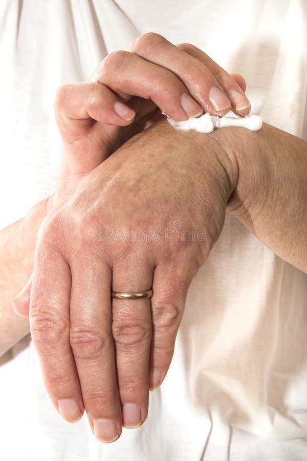 Donna senior che sfrega il suo polso con un dolore che allevia crema immagini stock libere da diritti Donna senior che sfrega il suo polso con un dolore che allevia crema immagini stock libere da diritti