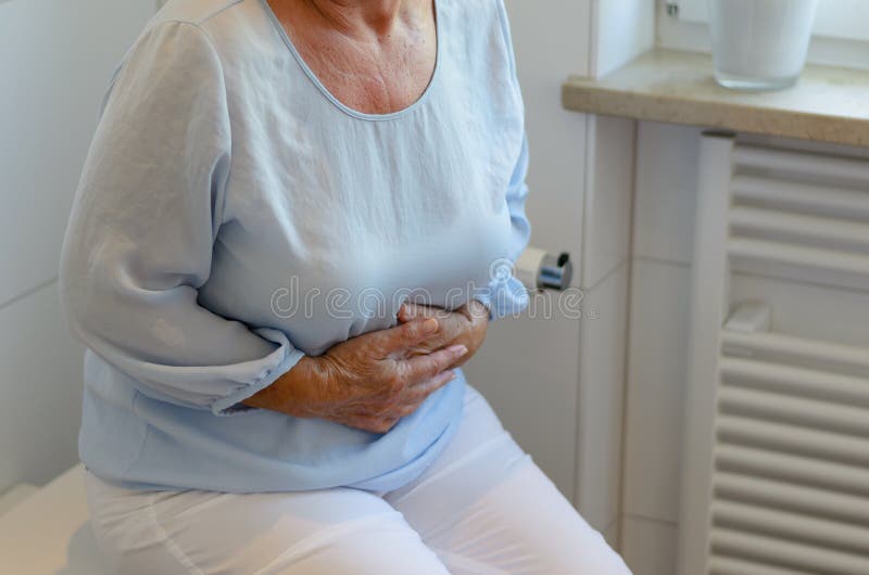 Donna senior che si siede sulla toilette immagine stock libera da diritti Donna senior che si siede sulla toilette immagine stock libera da diritti