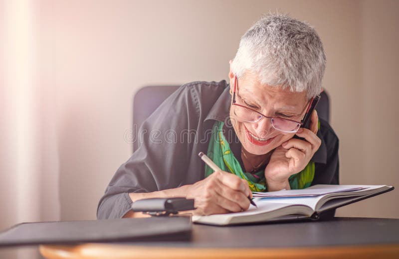 Donna senior di affari che prende giù gli ordini fotografie stock Donna senior di affari che prende giù gli ordini fotografie stock