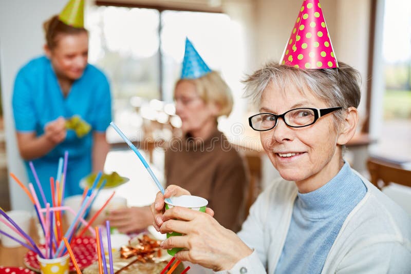 Donna senior nella casa di cura che celebra carnevale fotografie stock libere da diritti Donna senior nella casa di cura che celebra carnevale fotografie stock libere da diritti