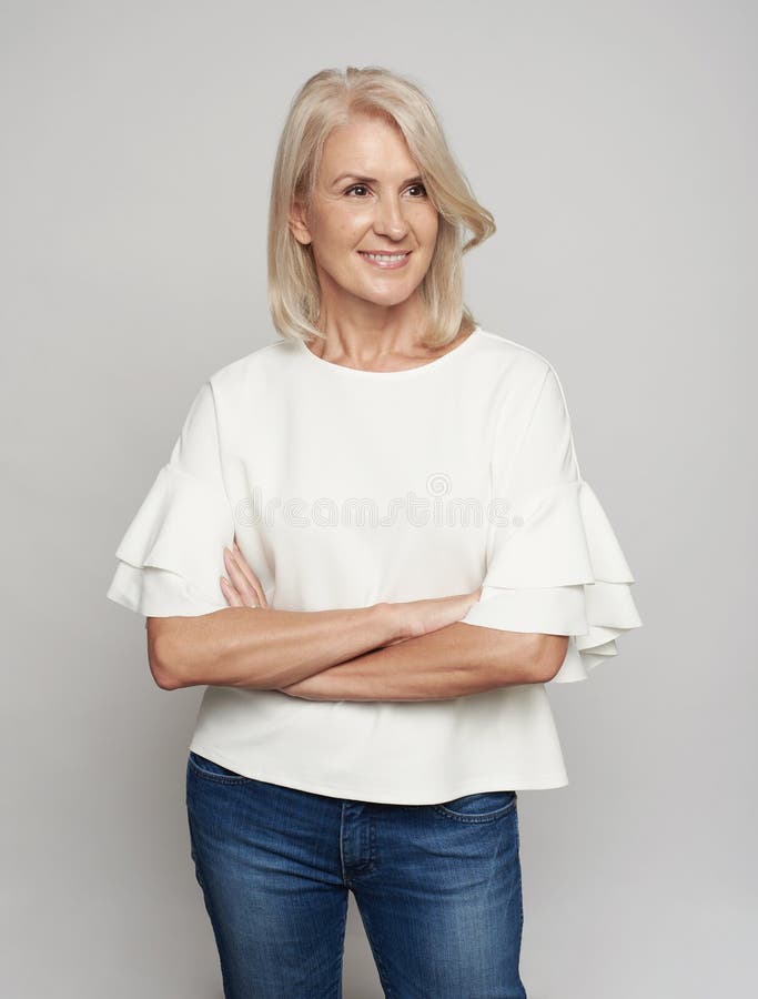 Donna senior piacevole con distogliere lo sguardo attraversato di armi fotografia stock Donna senior piacevole con distogliere lo sguardo attraversato di armi fotografia stock