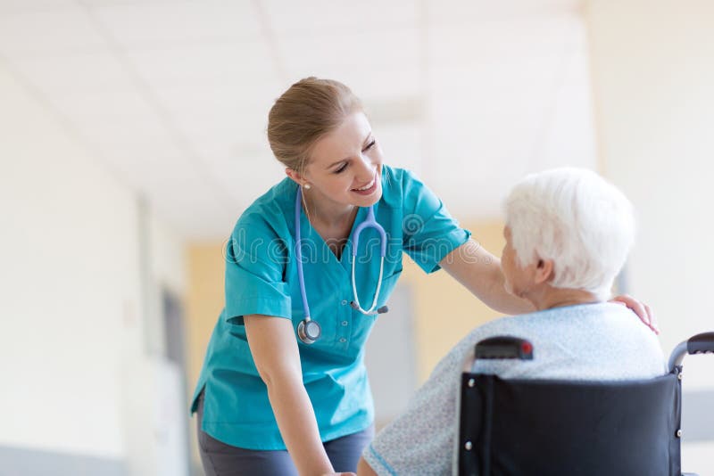 Donna senior in sedia a rotelle con l'infermiere in ospedale fotografie stock libere da diritti Donna senior in sedia a rotelle con l'infermiere in ospedale fotografie stock libere da diritti