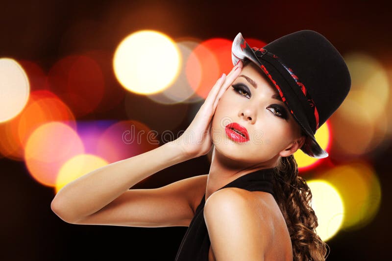 Donna sexy con le labbra rosse luminose ed il cappello alla moda