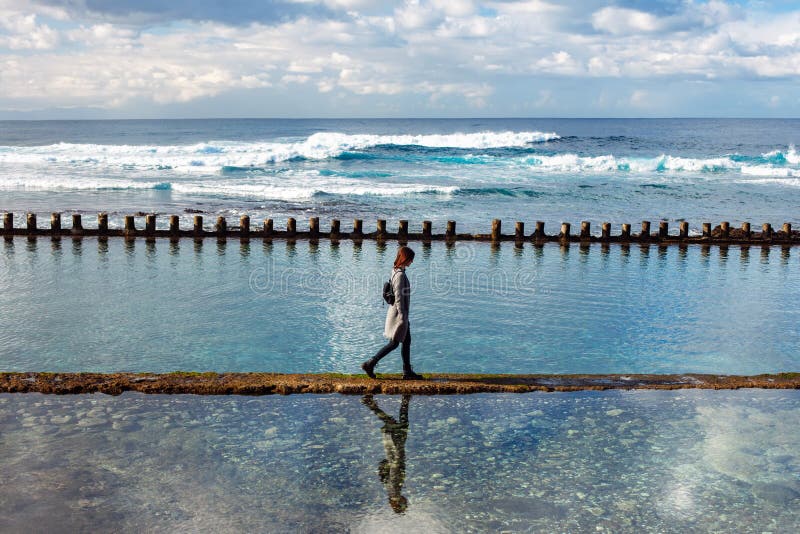 Donna sola che cammina sulla spiaggia dell'oceano fotografia stock libera da diritti Donna sola che cammina sulla spiaggia dell'oceano fotografia stock libera da diritti