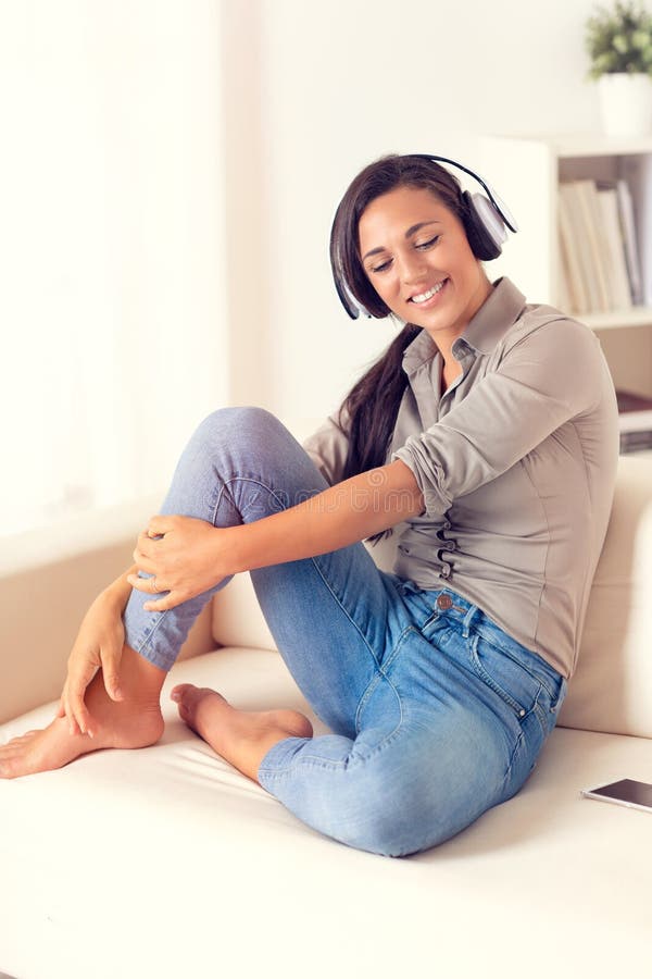 Donna sorridente che ascolta la musica con le cuffie immagini stock Donna sorridente che ascolta la musica con le cuffie immagini stock
