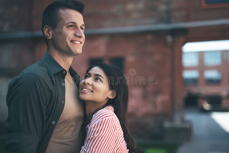 Donna sorridente che esamina ragazzo mentre abbracciandolo fotografie stock Donna sorridente che esamina ragazzo mentre abbracciandolo fotografie stock