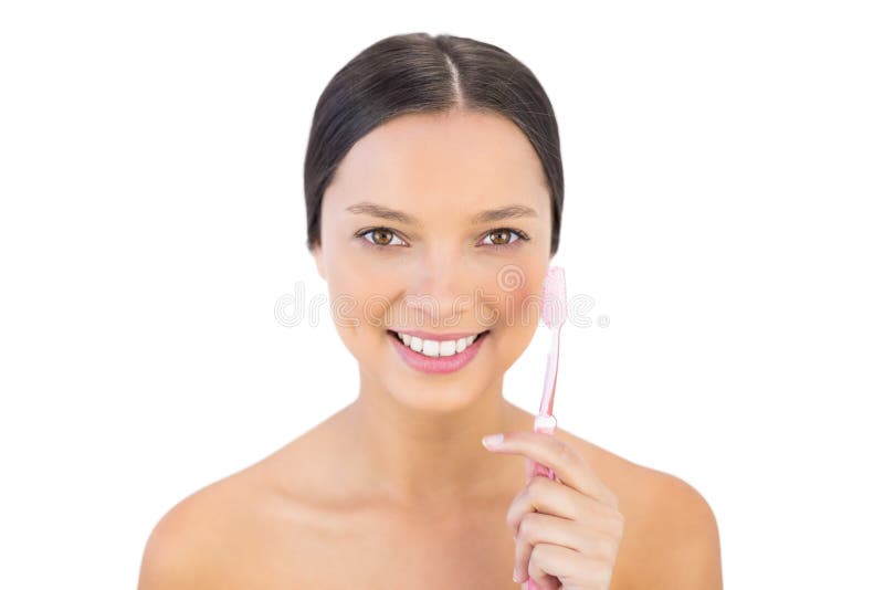 Donna sorridente che tiene la sua spazzola dei denti fotografia stock Donna sorridente che tiene la sua spazzola dei denti fotografia stock