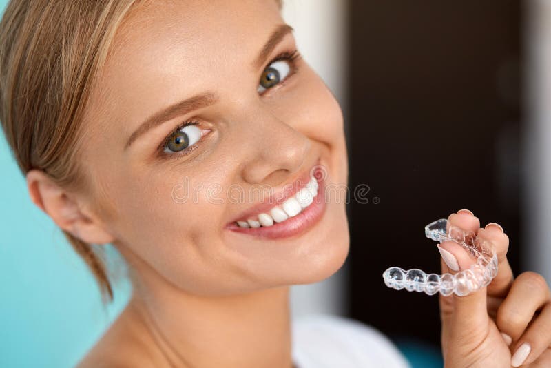 Donna sorridente con i denti bianchi che tengono i denti che imbianca vassoio