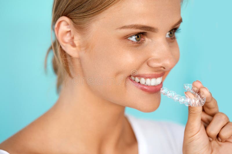 Donna sorridente con il bello sorriso facendo uso dell'istruttore invisibile dei denti immagini stock Donna sorridente con il bello sorriso facendo uso dell'istruttore invisibile dei denti immagini stock