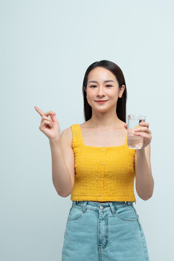 Donna sorridente con un bicchiere d'acqua e rivolta verso l'alto fotografia stock libera da diritti