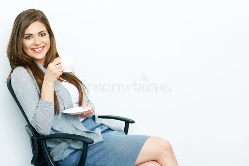 Donna sorridente di affari rilassata con la tazza di caffè che si siede in offic fotografia stock Donna sorridente di affari rilassata con la tazza di caffè che si siede in offic fotografia stock