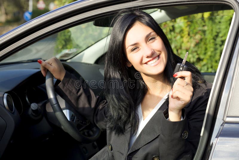 Donna sorridente felice dentro l'automobile che mostra le chiavi fotografie stock libere da diritti Donna sorridente felice dentro l'automobile che mostra le chiavi fotografie stock libere da diritti