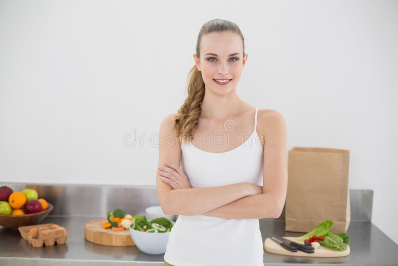 Donna sorridente graziosa che sta inter-armata fotografie stock libere da diritti Donna sorridente graziosa che sta inter-armata fotografie stock libere da diritti