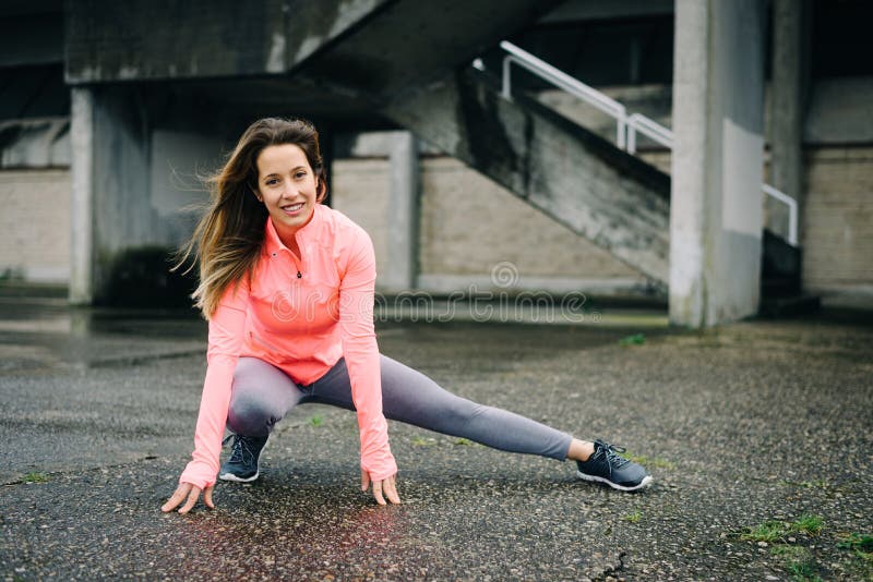 Donna sportiva sull'allenamento d'allungamento urbano di forma fisica fotografia stock libera da diritti Donna sportiva sull'allenamento d'allungamento urbano di forma fisica fotografia stock libera da diritti