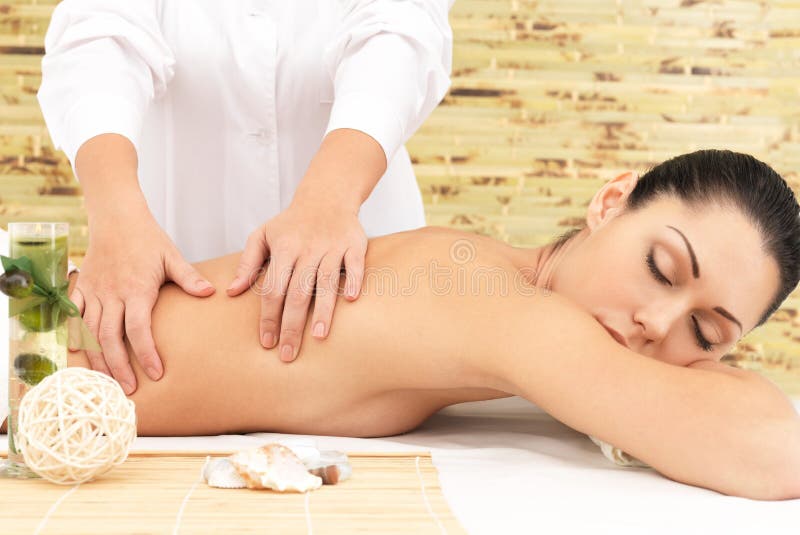 Donna sul massaggio di terapia della parte posteriore nel salone della stazione termale immagini stock libere da diritti Donna sul massaggio di terapia della parte posteriore nel salone della stazione termale immagini stock libere da diritti
