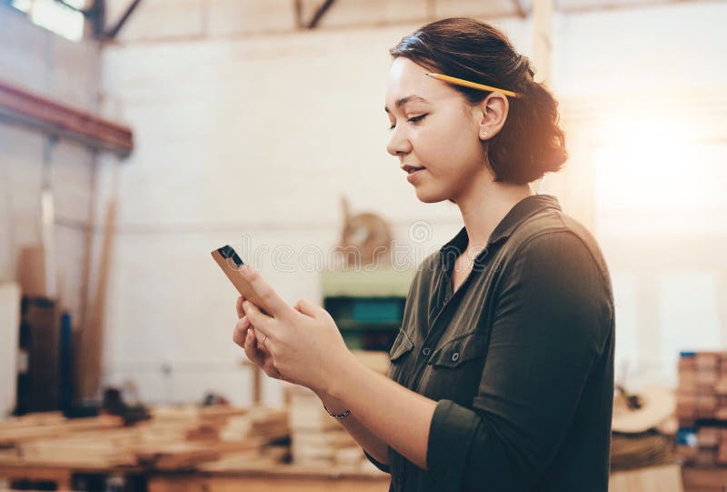 Donna telefono e carpentiere per la comunicazione in un laboratorio online e per ordinare provviste su app. falegnameria femminile fotografia stock