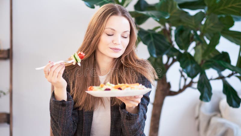 Donna in ufficio che mangia insalata al posto di lavoro Concetto di pranzo a lavoro ed a mangiare alimento sano Concetto sano di fotografia stock libera da diritti Donna in ufficio che mangia insalata al posto di lavoro Concetto di pranzo a lavoro ed a mangiare alimento sano Concetto sano di fotografia stock libera da diritti