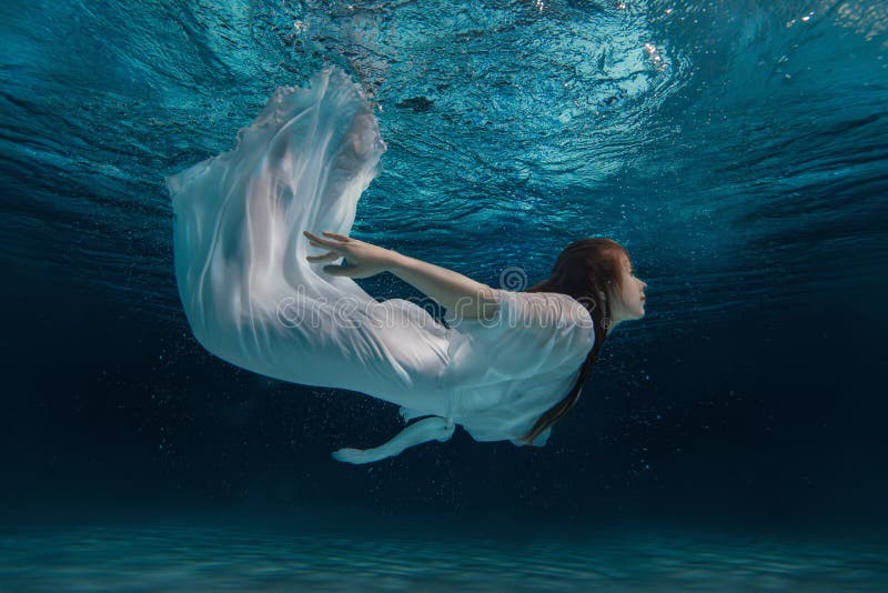 Donna in un vestito bianco sotto acqua fotografie stock libere da diritti Donna in un vestito bianco sotto acqua fotografie stock libere da diritti