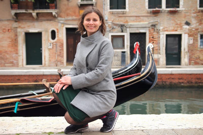 Donna a Venezia, Italia Ragazza sorridente sveglia sul canale veneziano con le gondole Giovane donna felice a Venezia fotografie stock Donna a Venezia, Italia Ragazza sorridente sveglia sul canale veneziano con le gondole Giovane donna felice a Venezia fotografie stock