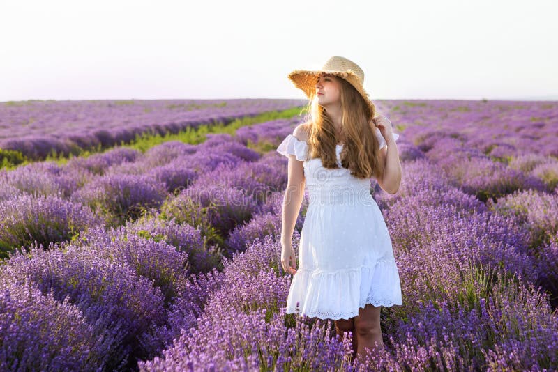 Donna in vestito bianco, cappello di paglia nel giacimento della lavanda fotografia stock libera da diritti Donna in vestito bianco, cappello di paglia nel giacimento della lavanda fotografia stock libera da diritti