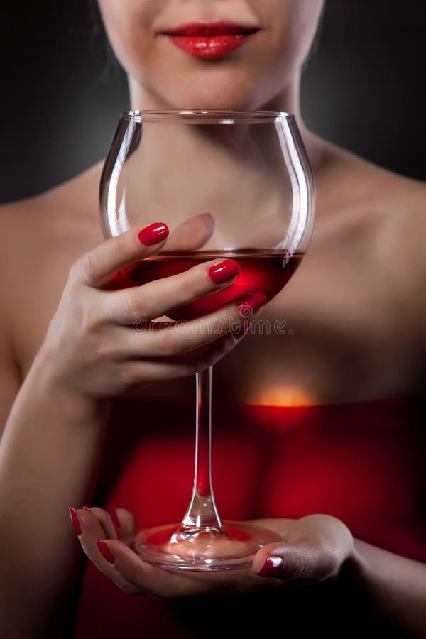Donna in vetro di vino rosso della holding fotografie stock libere da diritti Donna in vetro di vino rosso della holding fotografie stock libere da diritti