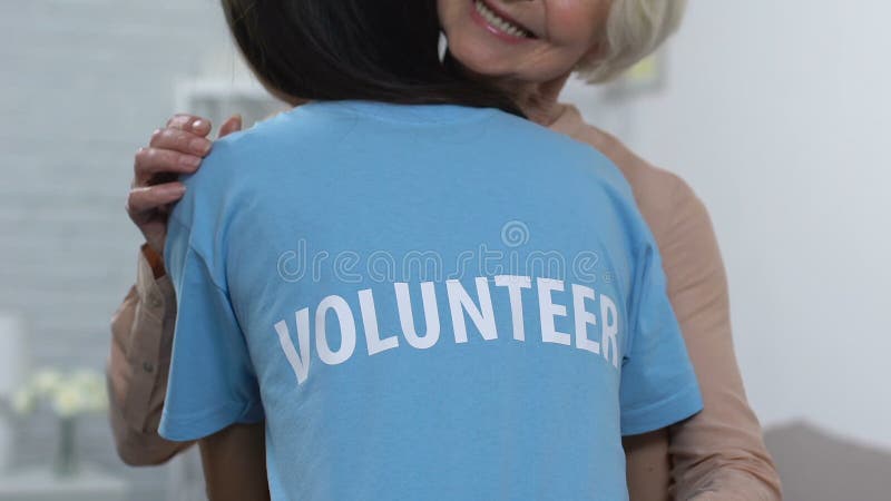 Donna volontaria abbracciando un'anziana signora sorridente in casa di riposo, assistenza e supporto
