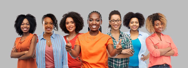 Donne afro-americane felici fanno vedere i pollici