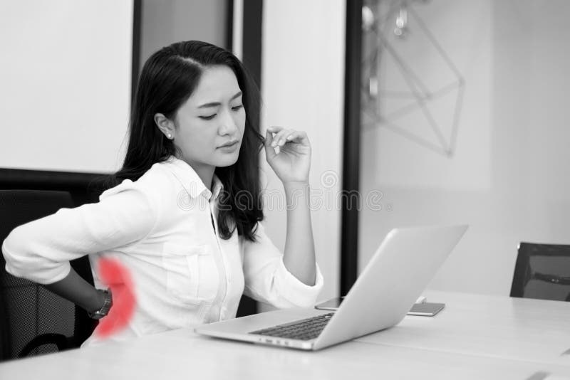 Donne asiatiche di affari con il peccato di dolore alla schiena un un ufficio e l'ha di lavoro fotografia stock libera da diritti Donne asiatiche di affari con il peccato di dolore alla schiena un un ufficio e l'ha di lavoro fotografia stock libera da diritti