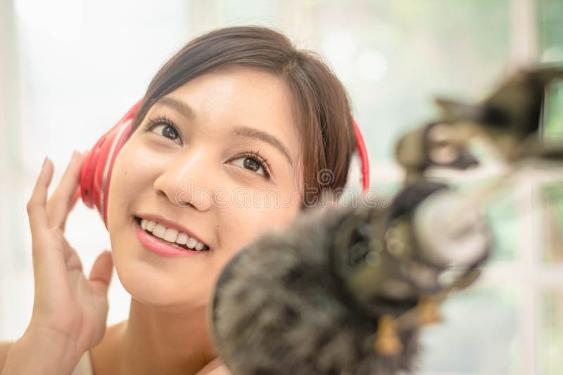 Donne asiatiche ravvicinate blogger di bellezza, attrattive e affascinanti, cantano con microfono, trasmettono in diretta tutoria immagini stock Donne asiatiche ravvicinate blogger di bellezza, attrattive e affascinanti, cantano con microfono, trasmettono in diretta tutoria immagini stock