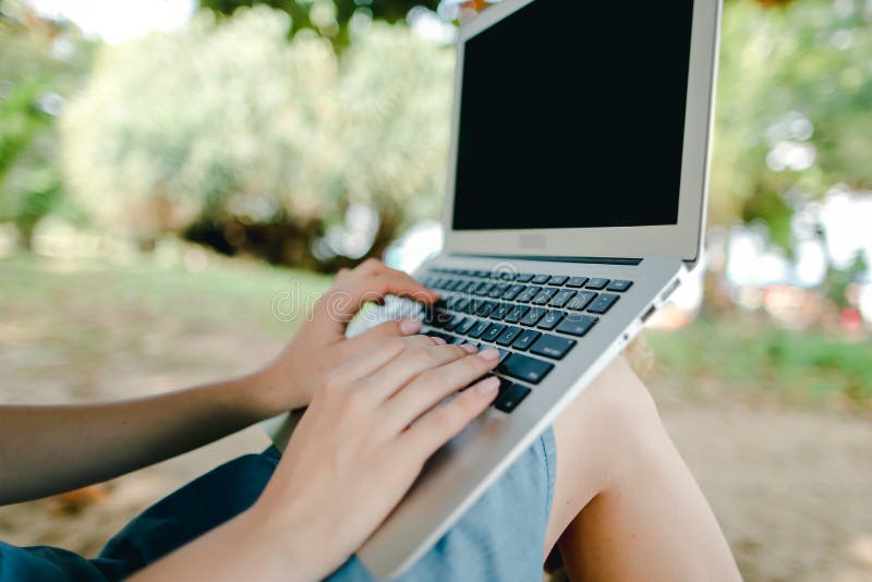 Donne belle mani con laptop con sabbia sullo schermo nero di sfondo. immagini stock