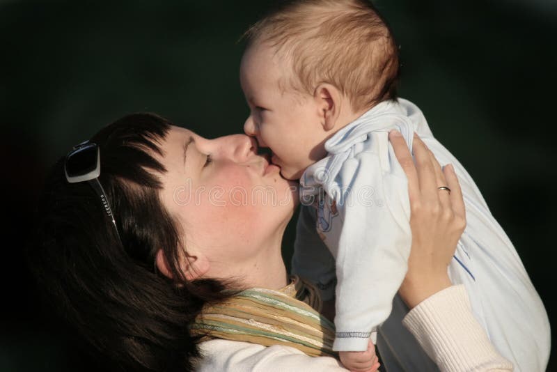 Donne che baciano il suo bambino fotografie stock Donne che baciano il suo bambino fotografie stock