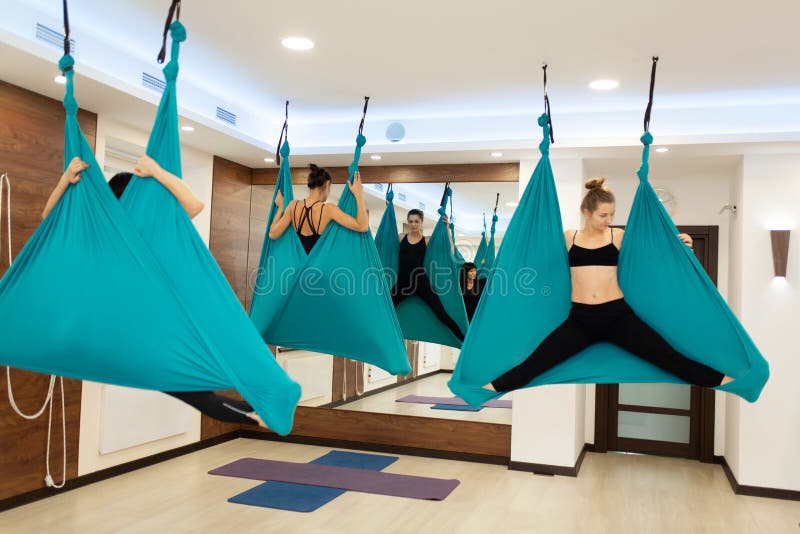 Donne che fanno yoga della mosca che allunga gli esercizi in amaca Stile di vita di benessere e di misura immagine stock Donne che fanno yoga della mosca che allunga gli esercizi in amaca Stile di vita di benessere e di misura immagine stock