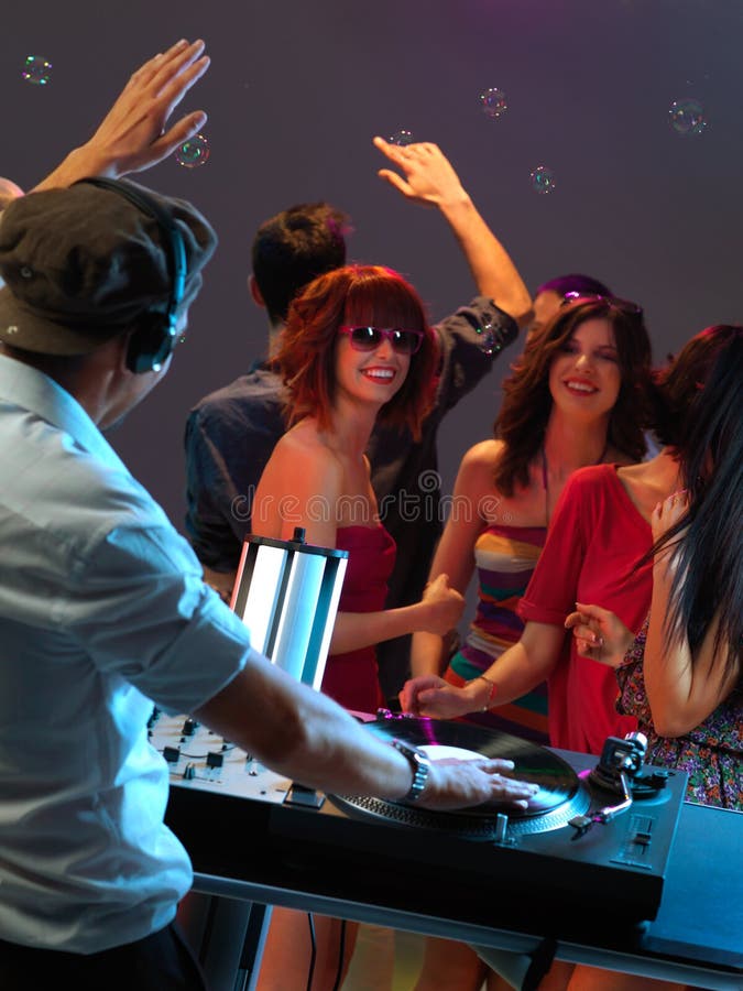 Donne che flirtano con il DJ nel randello di notte fotografia stock libera da diritti Donne che flirtano con il DJ nel randello di notte fotografia stock libera da diritti