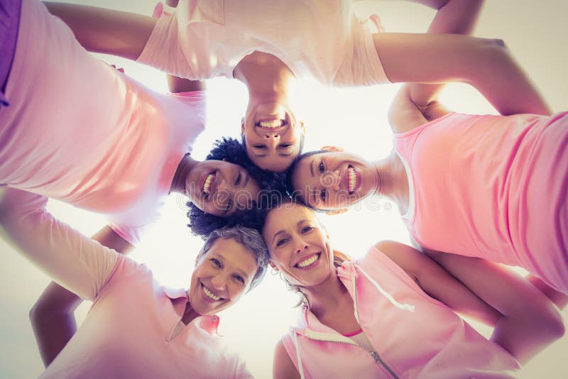 Donne che indossano rosa per cancro al seno con le armi intorno immagine stock Donne che indossano rosa per cancro al seno con le armi intorno immagine stock