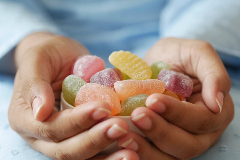 Donne con una ciotola di caramelle colorate alla gomma.