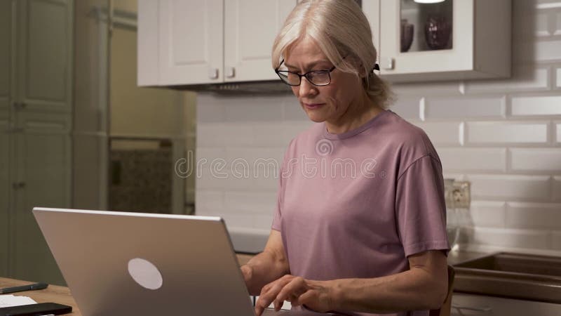 Donne concentrate che digitano laptop in ambienti accoglienti con concentrazione video d archivio