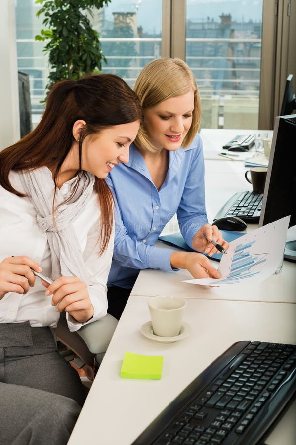 Donne di affari che discutono grafico nell'ufficio fotografia stock libera da diritti