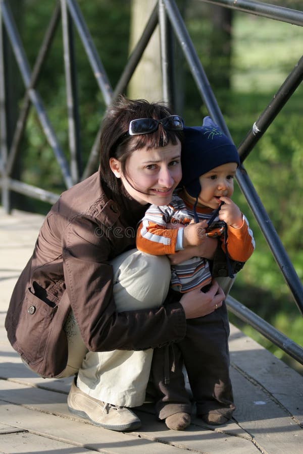 Donne di Squating con il bambino fotografia stock libera da diritti Donne di Squating con il bambino fotografia stock libera da diritti