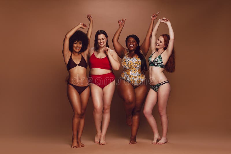 Donne differenti di dimensione in bikini che ballano insieme